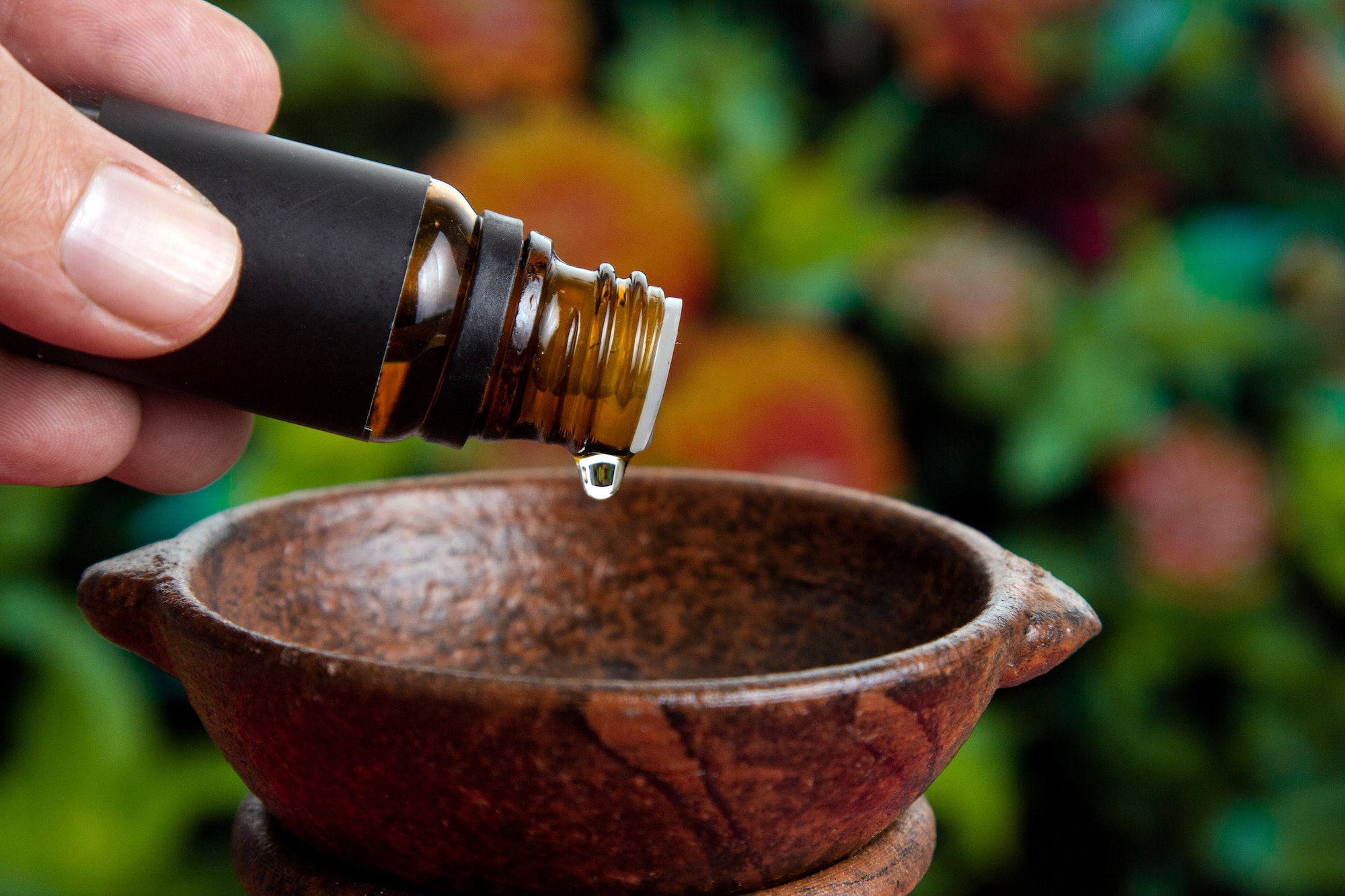 hands pouring essential oil